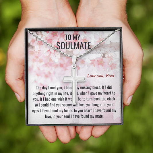 Necklace with cross pendant held in hands against a floral background